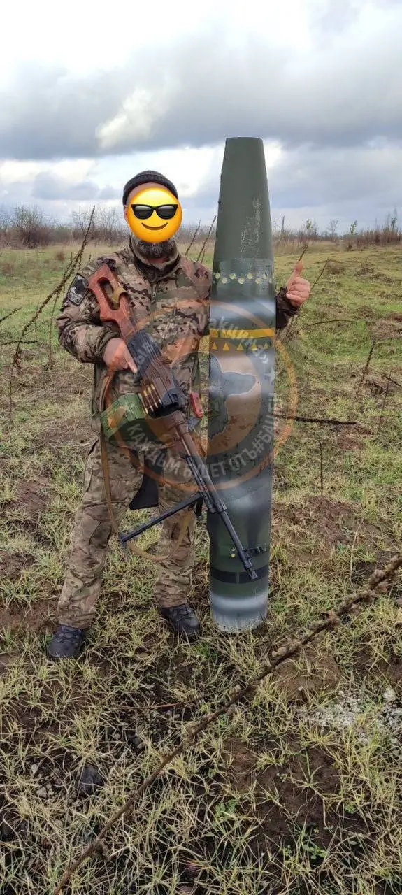 Russian soldier poses with the remains of a rocket with DM1443 munitions