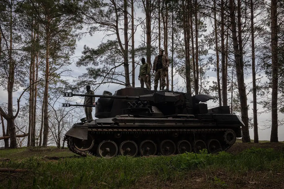 Ukrainian soldiers standing on a Gepard in a forest