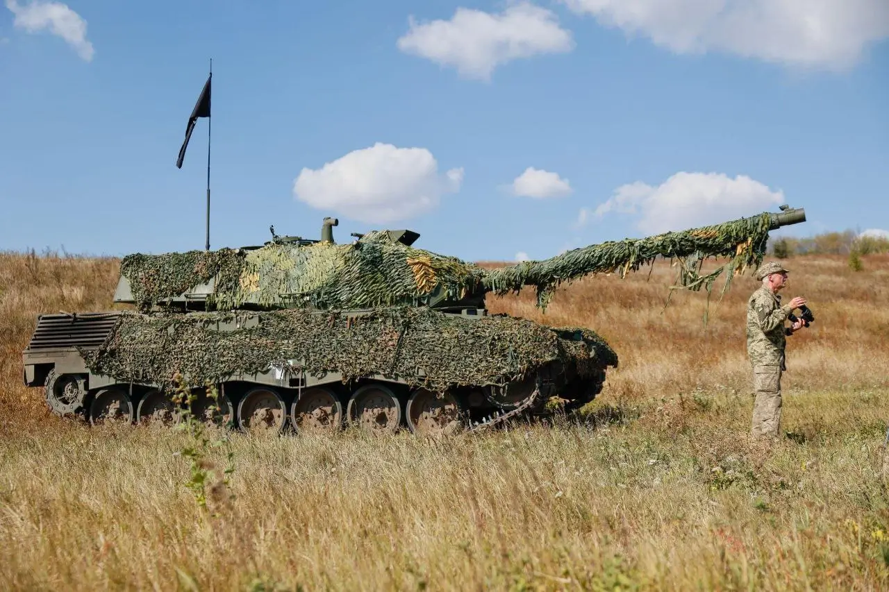 Ukrainian soldier standing in front of a Leopard 1A5