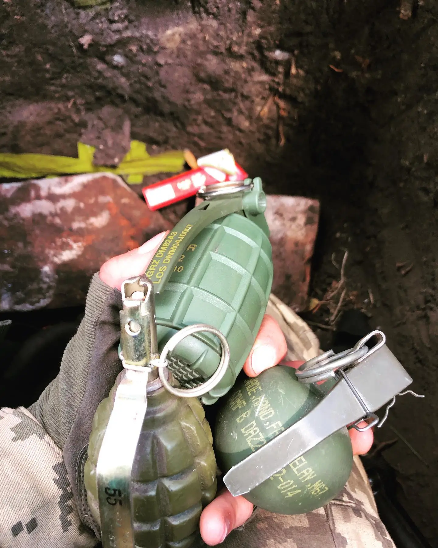 Ukrainian soldier holds various hand grenades