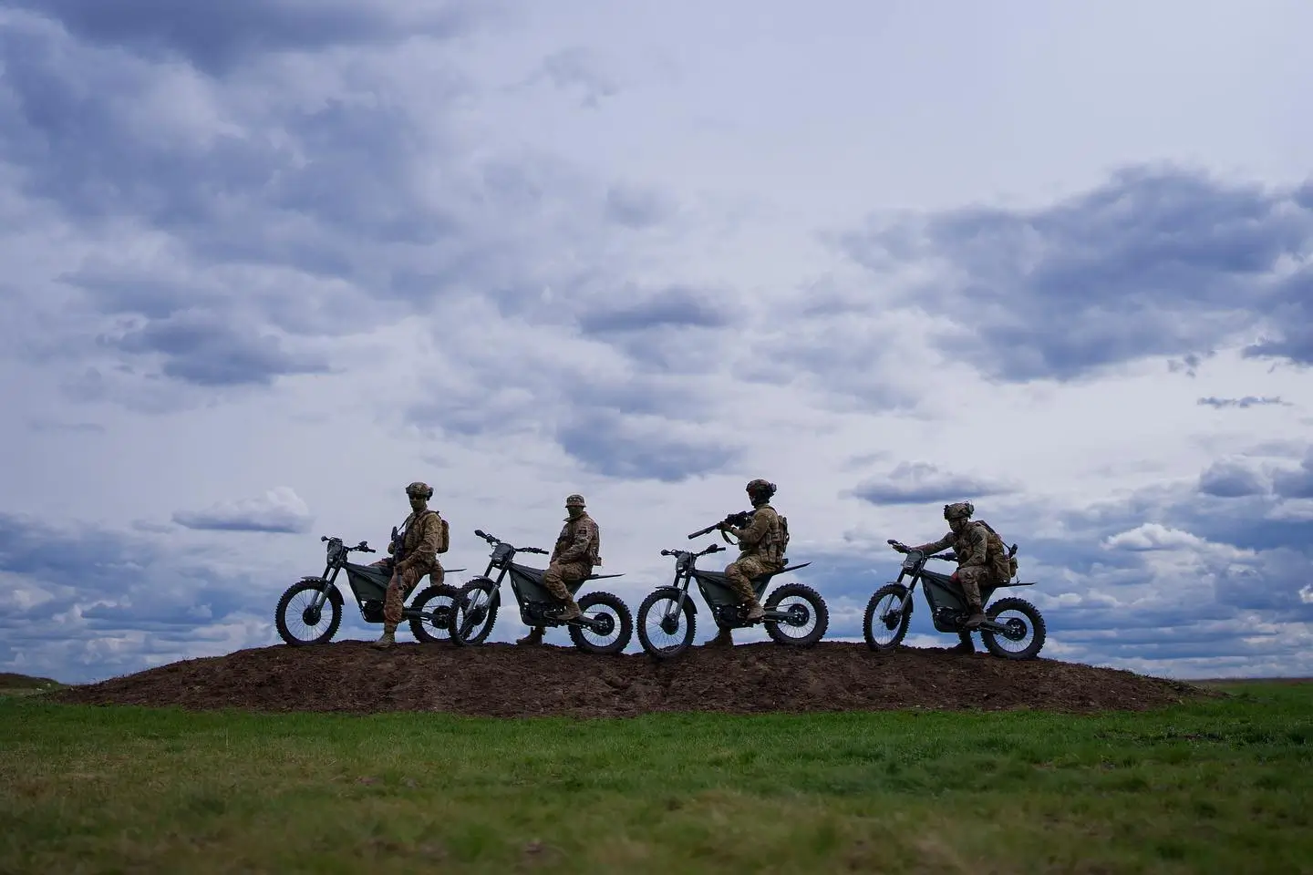 Four Ukrainian soldiers on E-Bike EMUs on a hill.