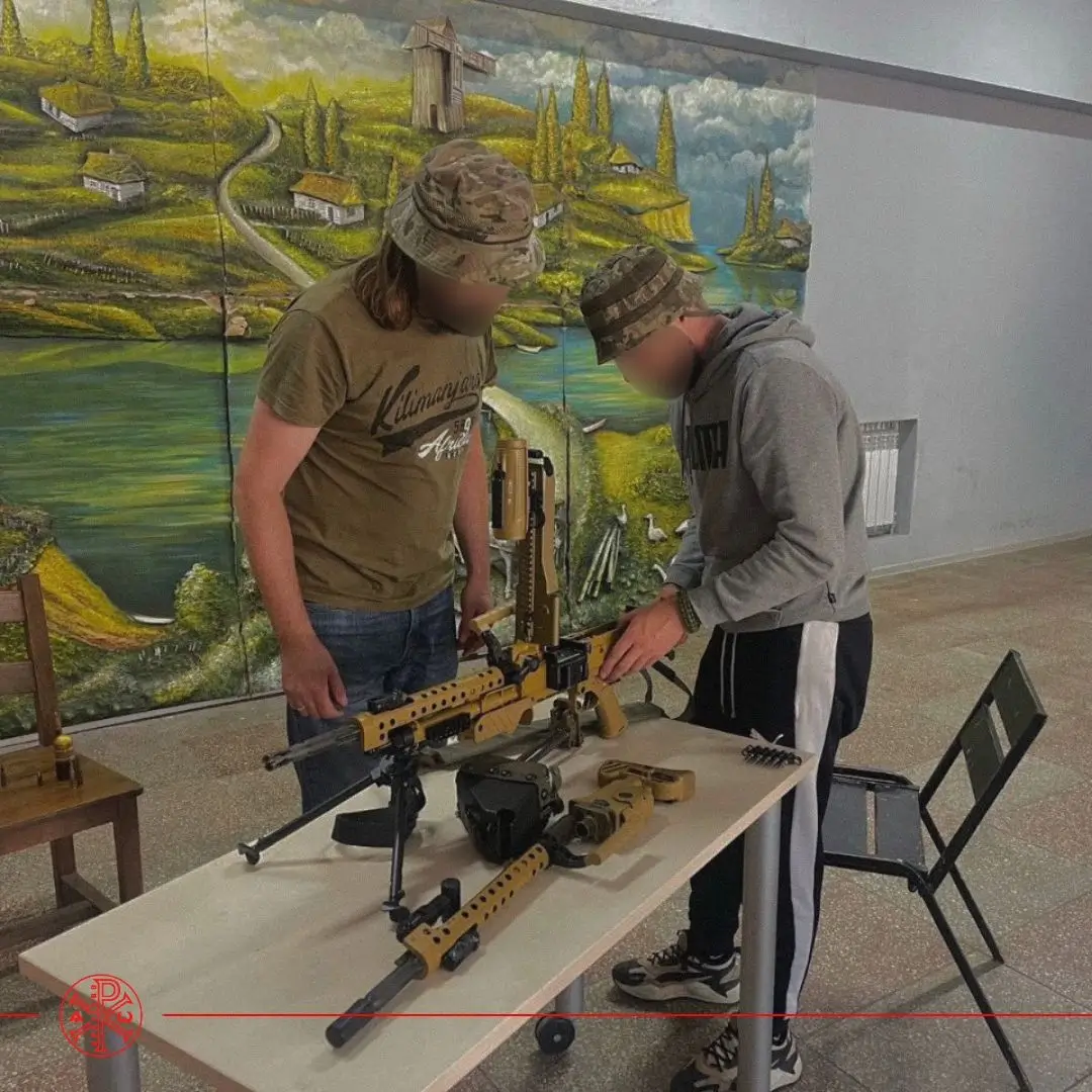 Two Ukrainian soldiers disassemble an MG5