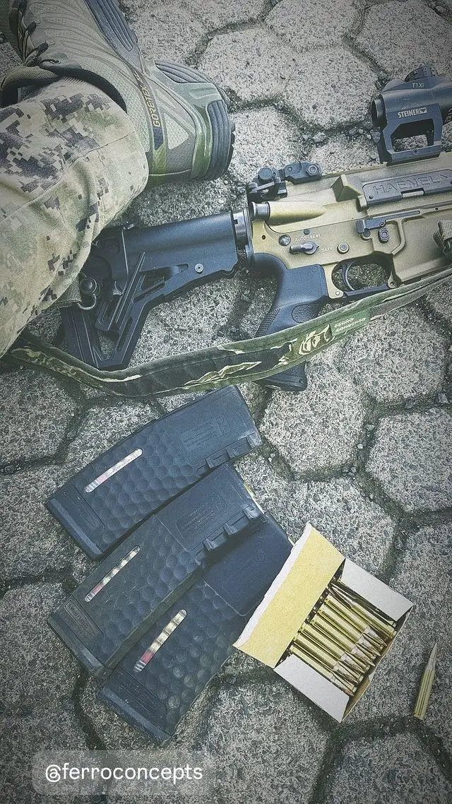 Close-up of an MK 556 with various magazines and ammunition