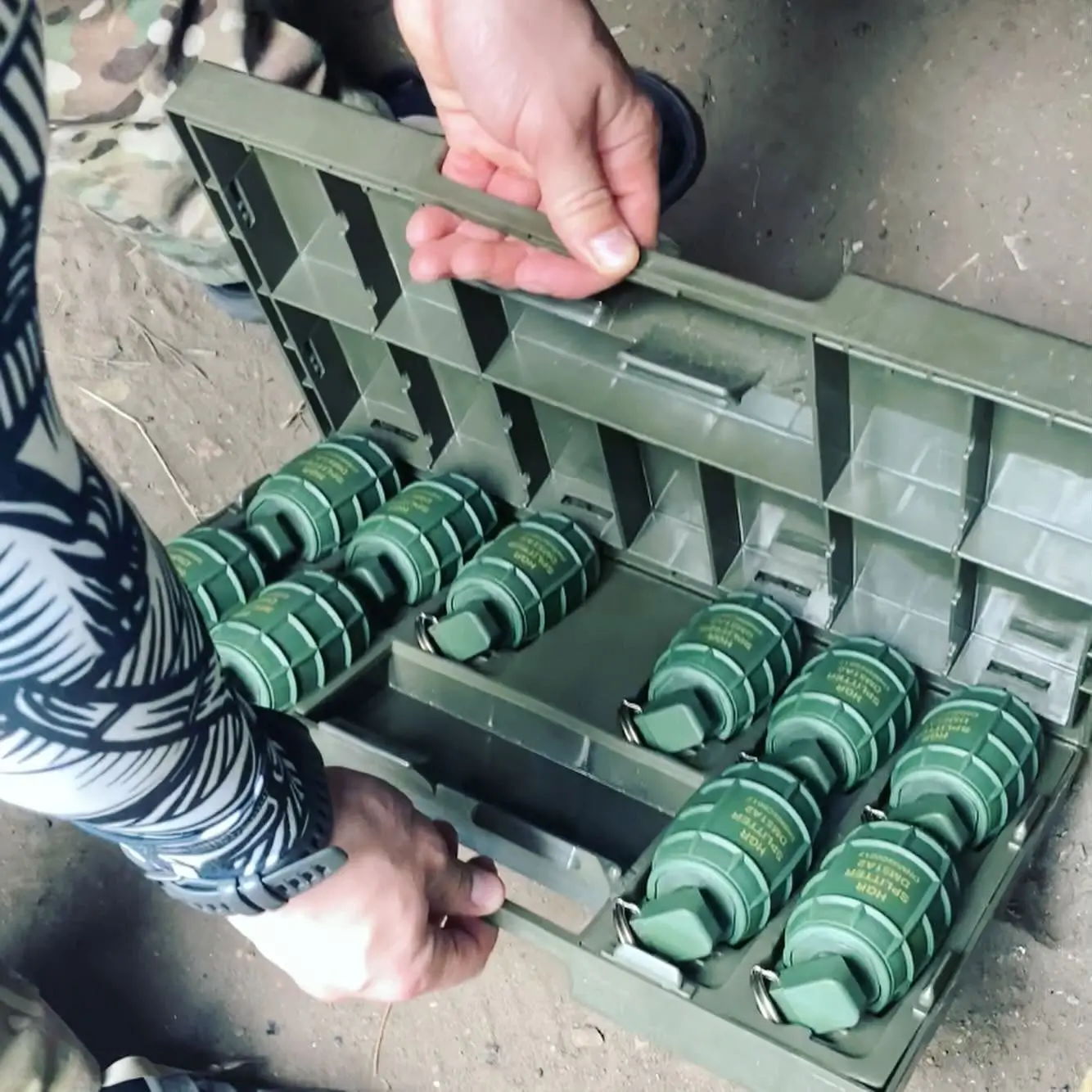 Soldier is showing DM51A2 hand grenades inside a case