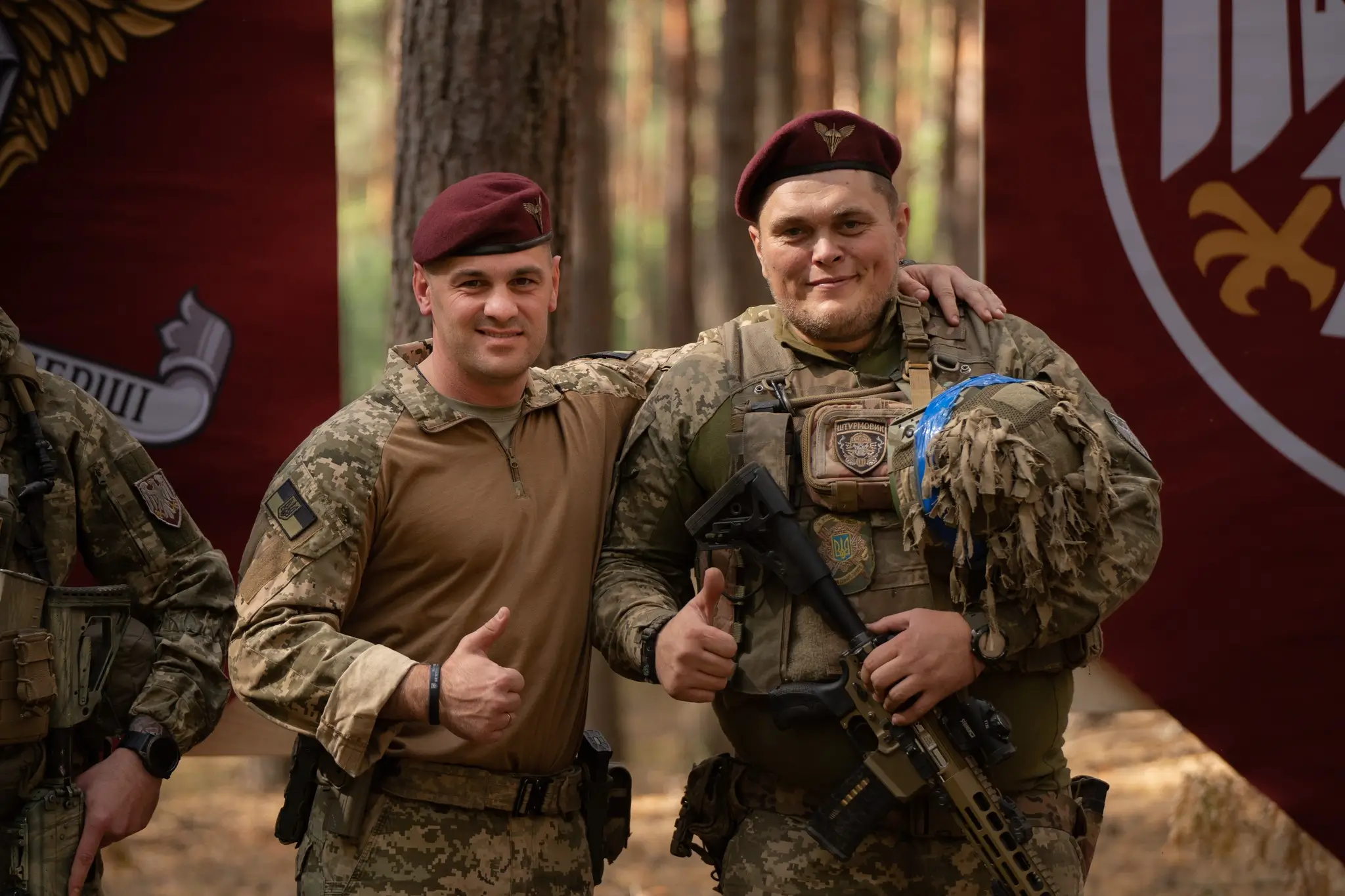 Two soldiers are posing with an MK 556 assault rifle