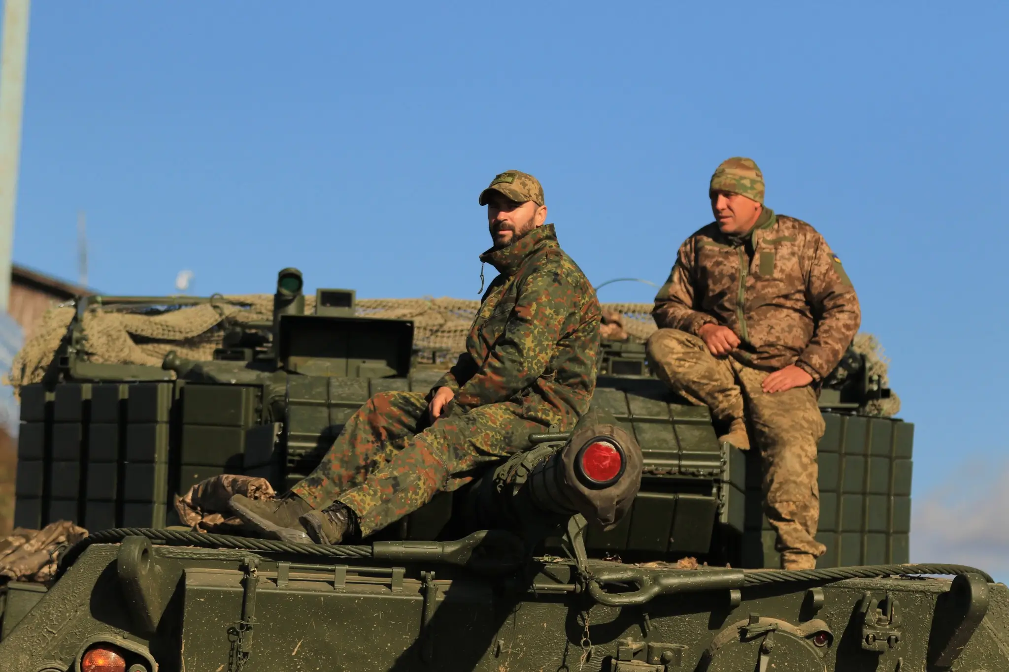 Soldiers sitting on top of a Leopard 1A5