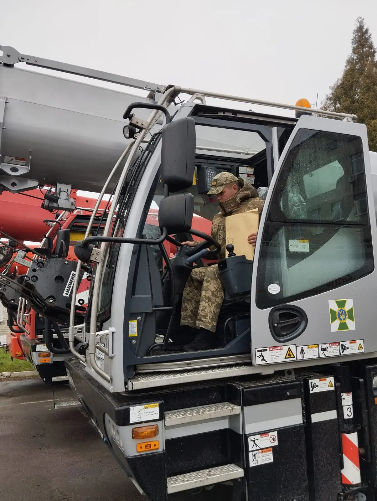 Ukrainian soldier sits in a heavy-duty crane