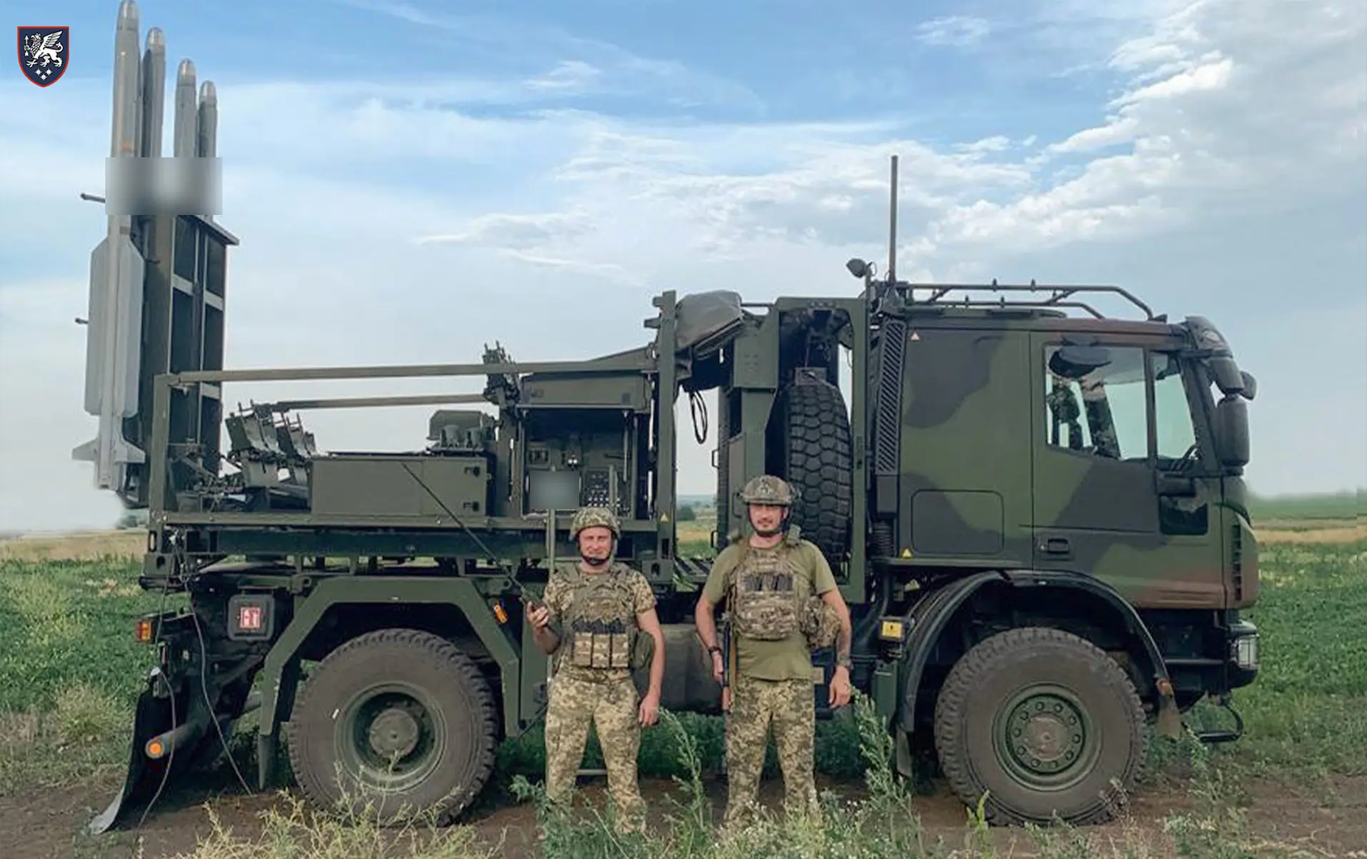 Ukrainian soldiers stand in front of an IRIS-T SLS launcher